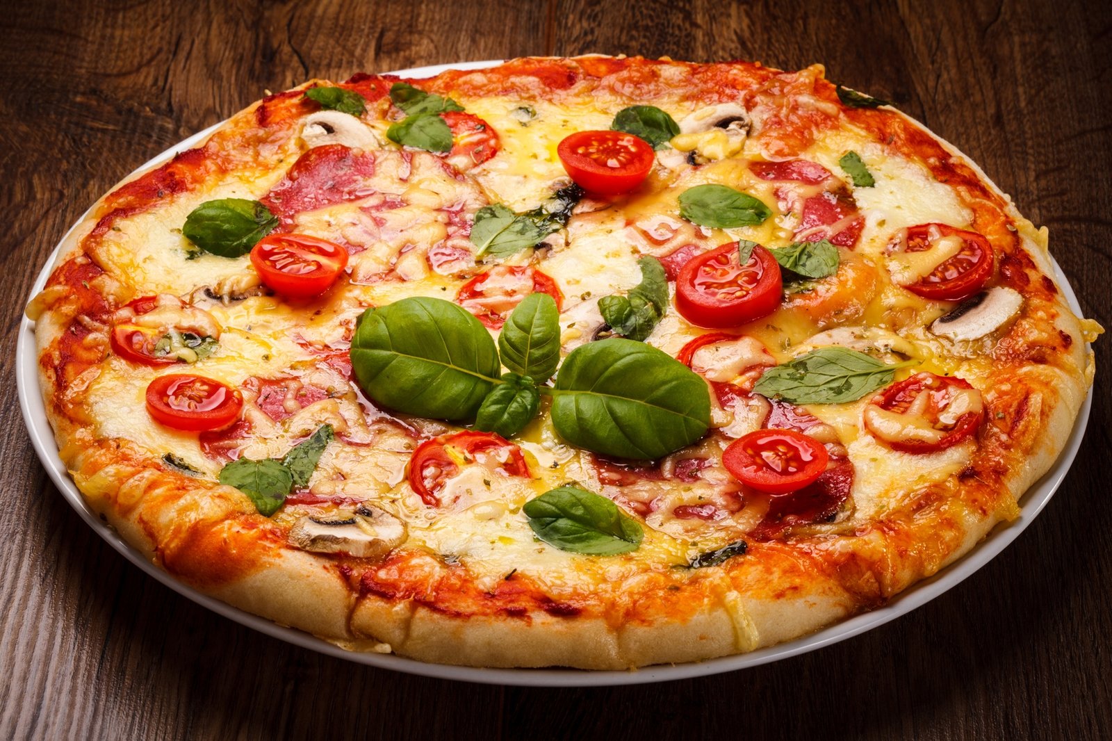 Pizza servita al tavolo di una pizzeria, spunto per riflettere sull'ordinaria incapacità italiana